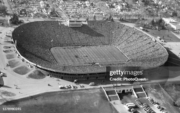 Aerial view of a capacity crowd for a football game at the University of Michigan's Stadium, Ann Arbor, Michigan, circa 1956. The largest...