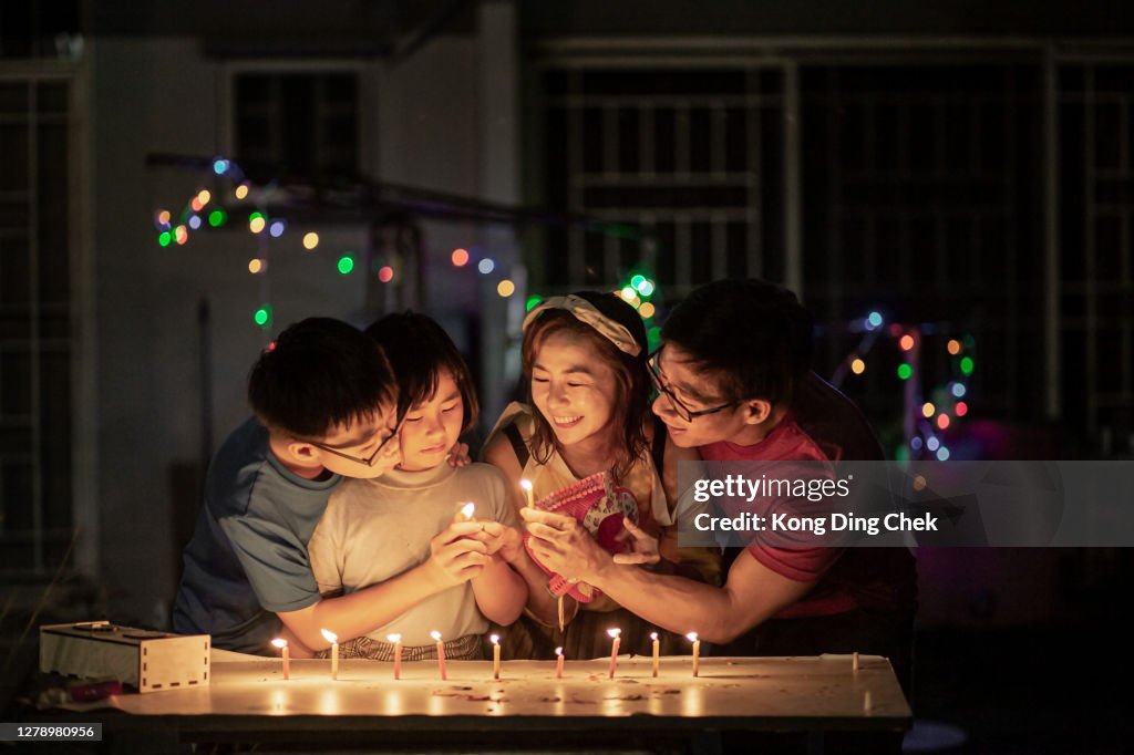 Asia Chinese family celebration moon cake festival. They light up the candle in public park with smiling face.