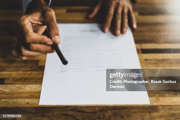 a man handing over of a pen over a contract - terms and conditions stock pictures, royalty-free photos & images