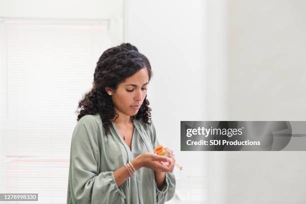 de vrouw giet uit pillen van fles op hand - pillen nemen stockfoto's en -beelden