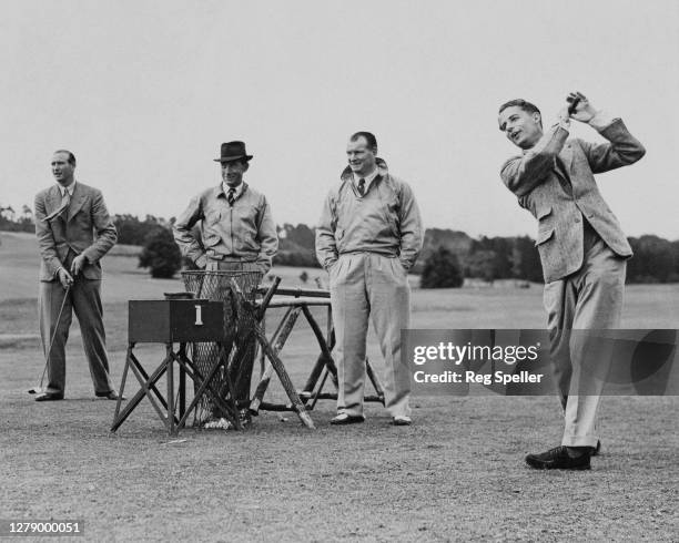 British Davis Cup tennis player Bunny Austin drives the ball off the 1st tee of the Royal Automobile Country Club course watched by trainer Tom...