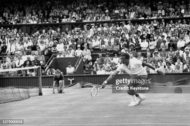 Arthur Ashe of the United States reaches to make a backhand return to Tom Okker of the Netherlands during their Men's Singles Quarter Final match at...