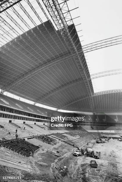 Construction work underway on the stands at the new Texas Stadium, with its distinctive partial roof covering most of the stands but not the playing...
