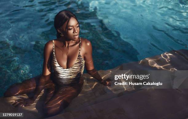 african beautiful young woman sitting by the pool in her bikini. - swimwear fashion stock pictures, royalty-free photos & images