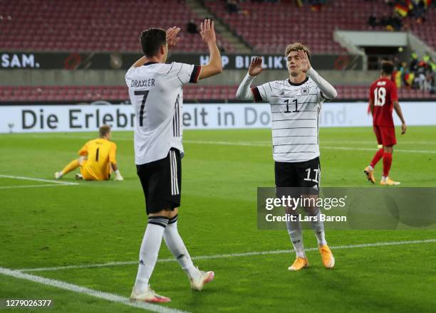 Julian Draxler of Germany celebrates with Luca Waldschmidt of Germany after scoring his team's first goal during the international friendly match...