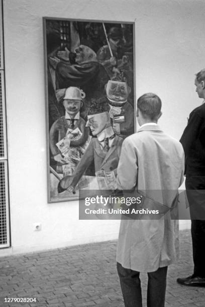 Visitors adoring a painting by George Grosz at the Academy of arts in Berlin, Germany 1962.