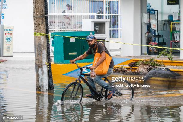 Man rides a bicycle on a flooded street in Cozumel after Hurricane Delta struck near the city on October 07, 2020 in Cozumel, Mexico. Hurricane Delta...