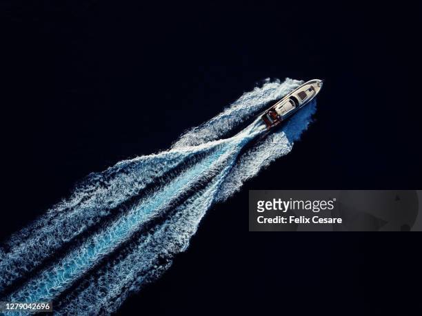 aerial top view of a luxury motor yacht speeding in open waters - upper class stock pictures, royalty-free photos & images