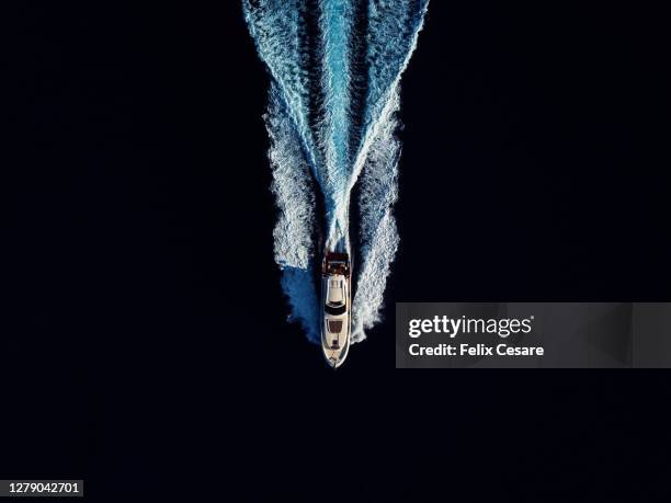 aerial top view of a luxury motor yacht speeding in open waters - high contrast background stock pictures, royalty-free photos & images