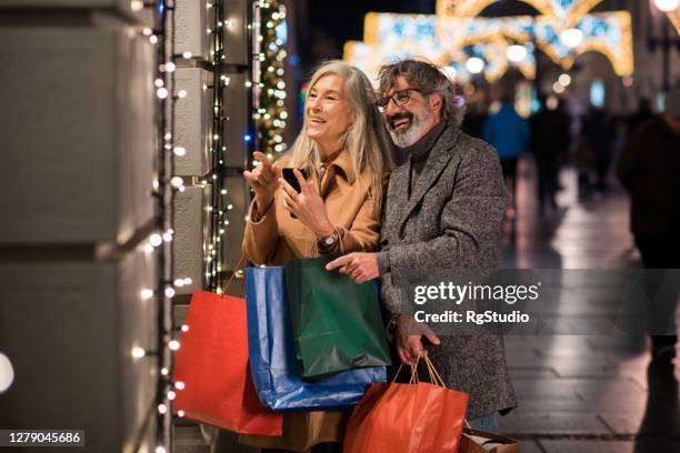 casal feliz e maduro comprando presentes para o ano novo - 63 year old female - fotografias e filmes do acervo