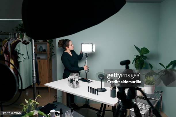 female vlogger fixing light of recording set - tutorial stock pictures, royalty-free photos & images