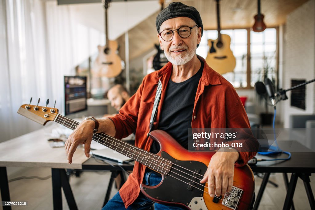 Retrato de músico senior con guitarra eléctrica