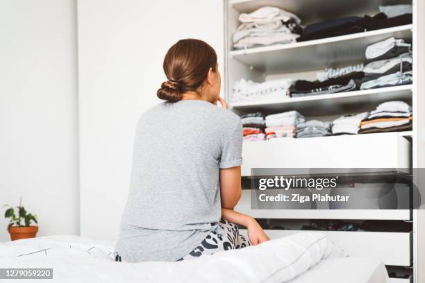 donna con i capelli in un panino che decide cosa indossare - order foto e immagini stock