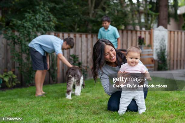 beautiful eurasian mother teacher her baby girl to walk - pacific islander ethnicity stock pictures, royalty-free photos & images