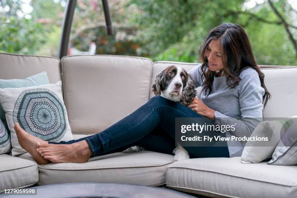 attractive mixed race woman spending time with her dog outside - garden furniture stock pictures, royalty-free photos & images