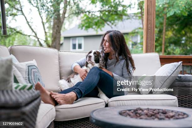 beautiful eurasian woman spending time with her dog outside - suburban lifestyles stock pictures, royalty-free photos & images