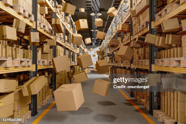 boîtes en carton qui s’effondrent et volent dans l’entrepôt - rempli photos et images de collection