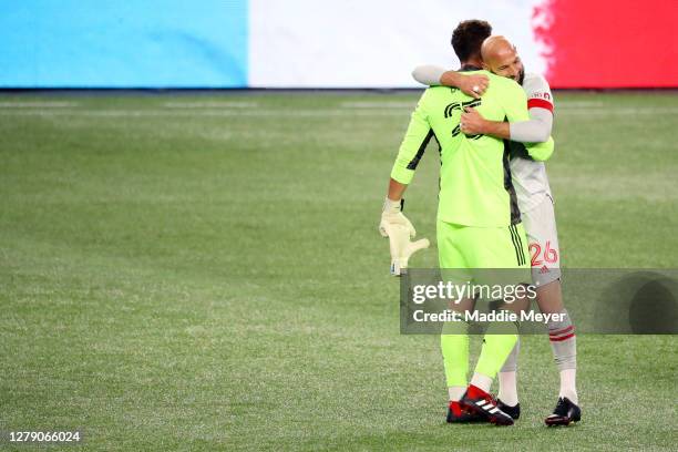 Alex Bono and Laurent Ciman of Toronto FC celebrate after Toronto FC defeat theNew England Revolution 1-0 at Gillette Stadium on October 07, 2020 in...