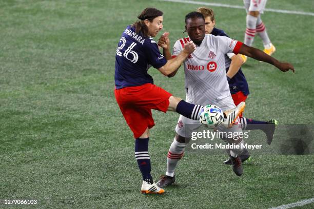 Tommy McNamara of the New England Revolution and Ayo Akinola of Toronto FC battle for control of the ball during the first half at Gillette Stadium...