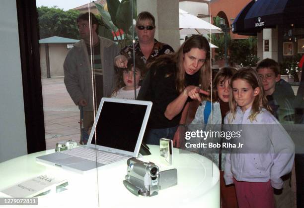 Customers look through the window at the Apple Store during grand opening, May 19, 2001 in Glendale, California.