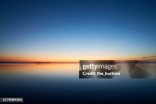 Sunset by the sea, the sky is reflected in the smooth sea Sunset by the sea, the sky is reflected in the smooth sea