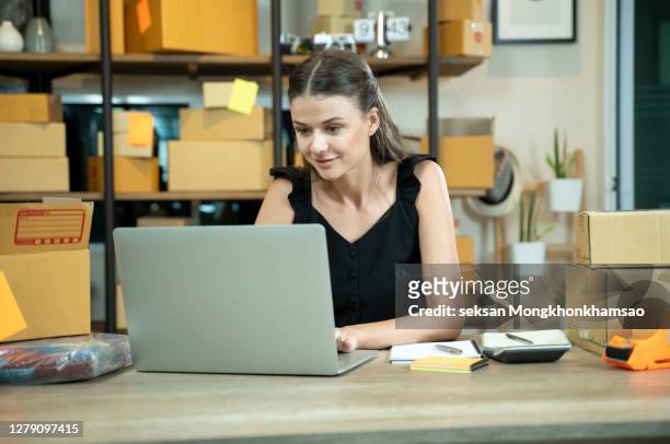 woman is working at warehouse for online store. - office small business stock-fotos und bilder