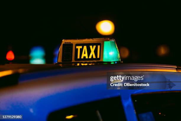 luminous of a lit taxi in madrid, spain at night - taxi imagens e fotografias de stock