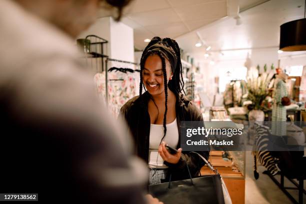 happy female customer buying clothes from salesman at store - customer experience stock pictures, royalty-free photos & images