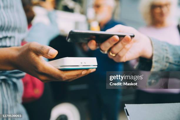 cropped hand of customer paying through smart phone in city - food truck payments stock pictures, royalty-free photos & images