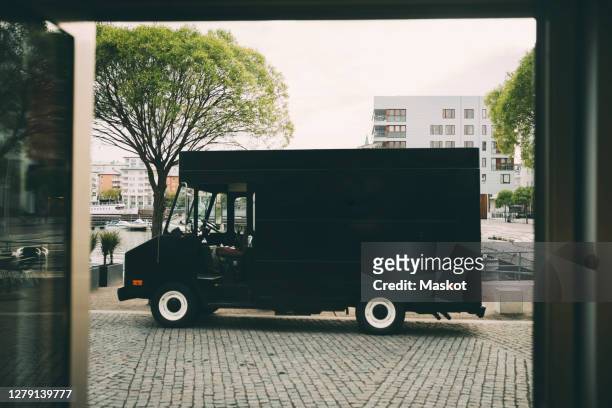 commercial land vehicle parked on street in city - foodtruck stockfoto's en -beelden