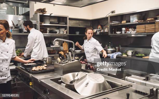 chefs working in commercial kitchen at restaurant - attentif photos et images de collection