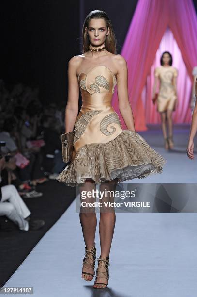 Model walks the runway as Les Brigittes perform during the Viktor&Rolf Ready to Wear Spring / Summer 2012 show during Paris Fashion Week at Espace...
