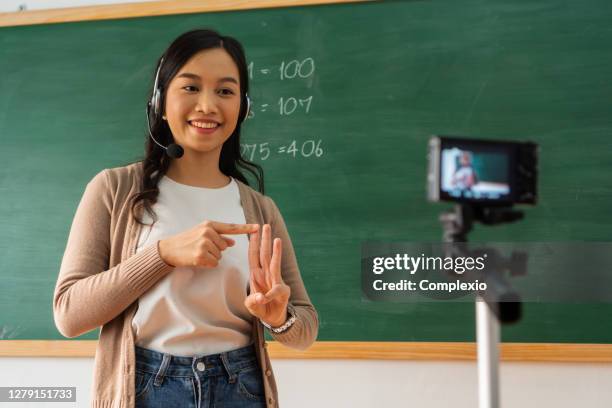 asian school teacher delivering online course - teaching remotely stock pictures, royalty-free photos & images