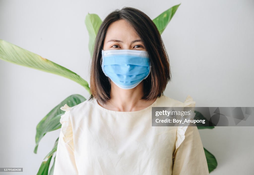 Portrait of young Asian woman smiling behind the mask.