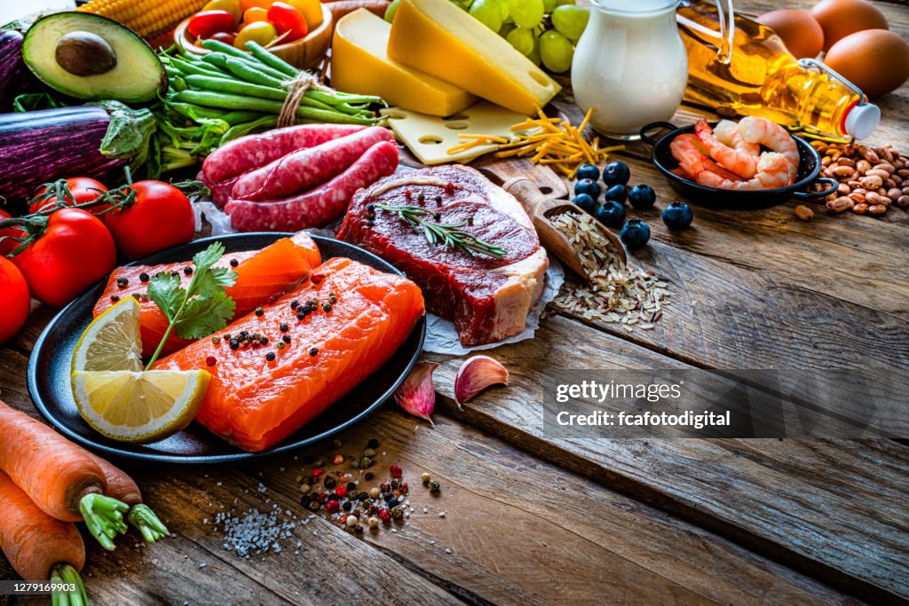 Group of food containing carbohidrates, protein and dietary fiber shot on wooden table.