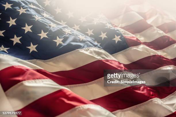 american flag waving in the wind - american symbol of 4th of july independence day democracy and patriotism. - stars and stripes stockfoto's en -beelden