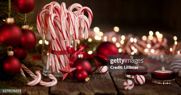 candy canes and bright christmas lights on an old wood background - christmas mints stock pictures, royalty-free photos & images