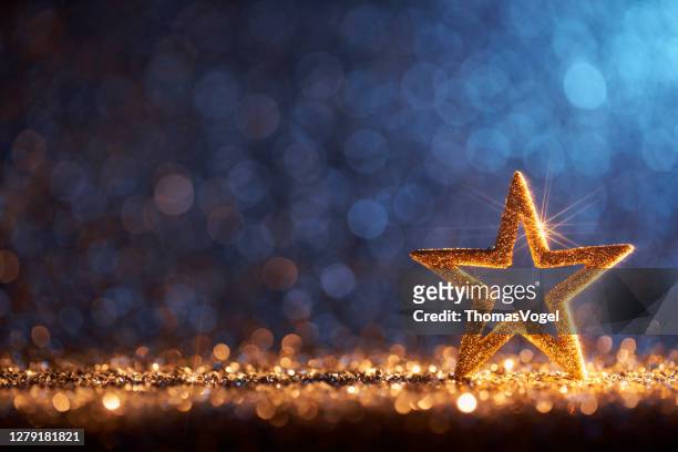 estrella de navidad dorada brillante - decoración de ornamento desenfocado fondo bokeh - celebration fotografías e imágenes de stock