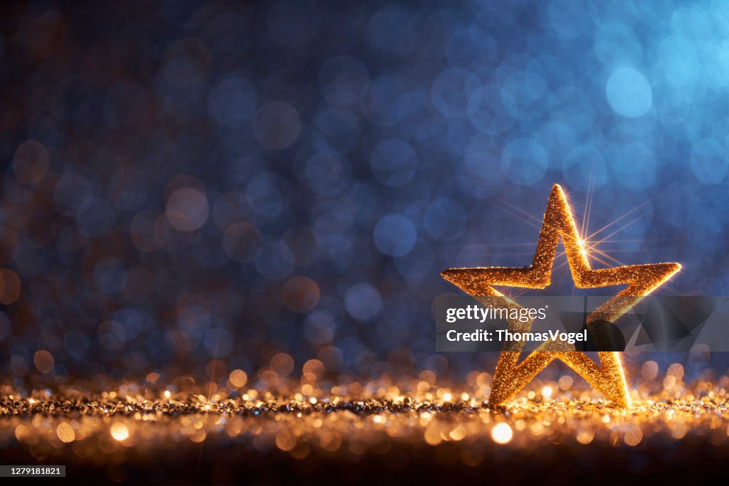 閃閃發光的金色聖誕之星 - 裝飾裝飾散角散景背景。