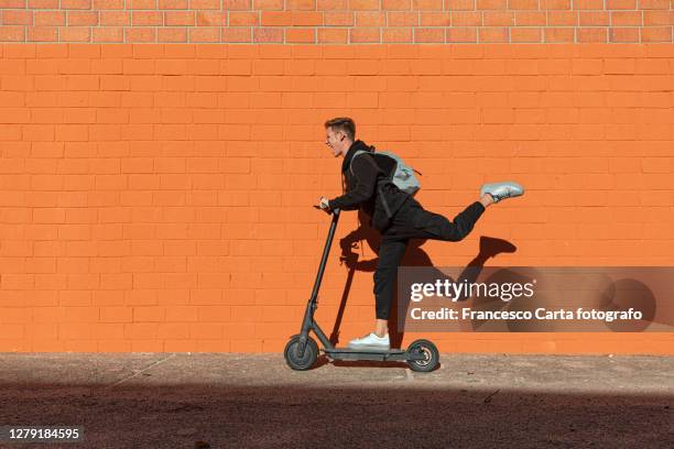 teenager riding electric scooter - push scooter stock pictures, royalty-free photos & images