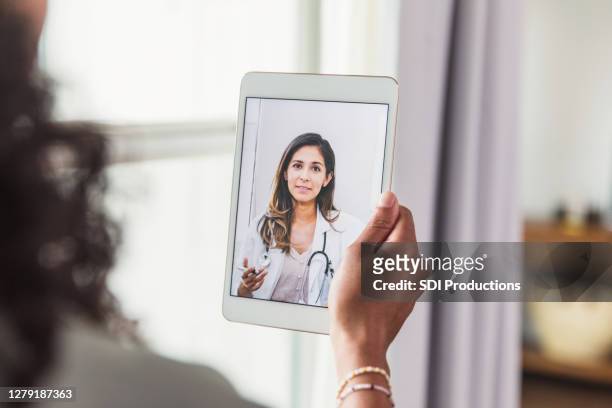 unrecognizable woman talks with doctor during telemedicine visit - online chat imagens e fotografias de stock