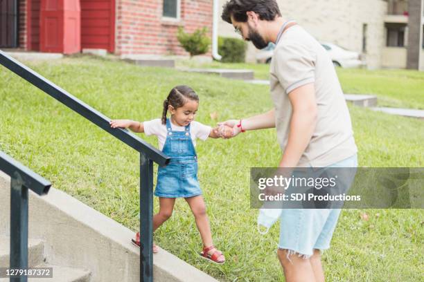 little girl tries walking on wall beside front steps - kid looking down stock pictures, royalty-free photos & images