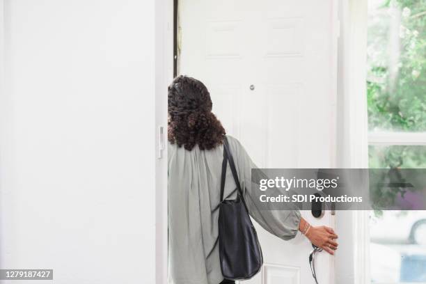 unrecognizable young adult woman walks out front door - abrir a porta sair imagens e fotografias de stock
