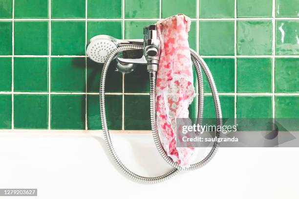 panties hanging from a bathtub faucet - tanga stock-fotos und bilder