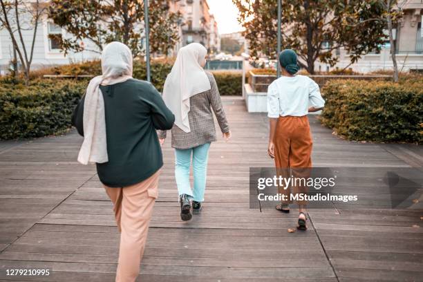 three friends walking down the street - islamic action front stock pictures, royalty-free photos & images