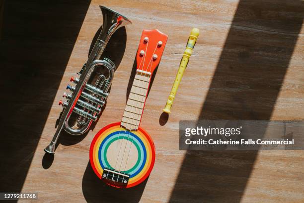 three toy instruments - a banjo, a trumpet and a recorder. - muzieksymbool stockfoto's en -beelden