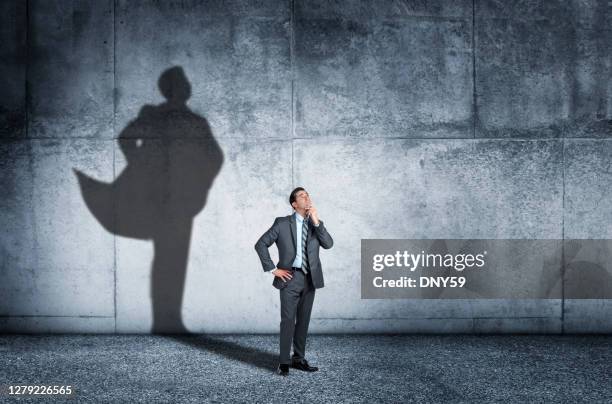 shadow of man aspiring to confidence - super hero capes stock pictures, royalty-free photos & images