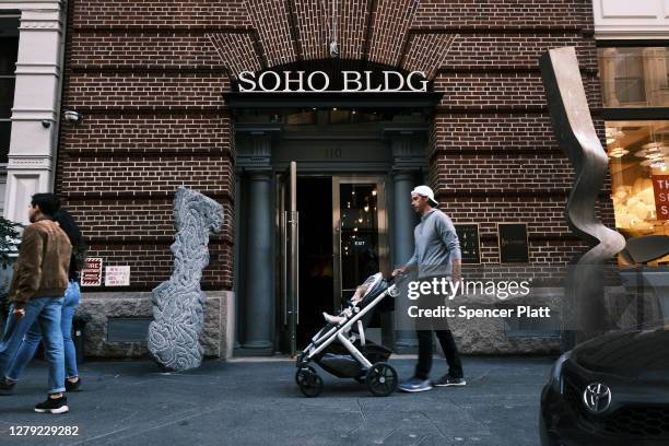 People walk through Manhattan’s SoHo neighborhood, which is home to numerous upscale stores, boutiques, art galleries and multimillion-dollar lofts...