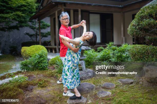 happy senior couple in front of their home - older couple ballroom dancing stock pictures, royalty-free photos & images