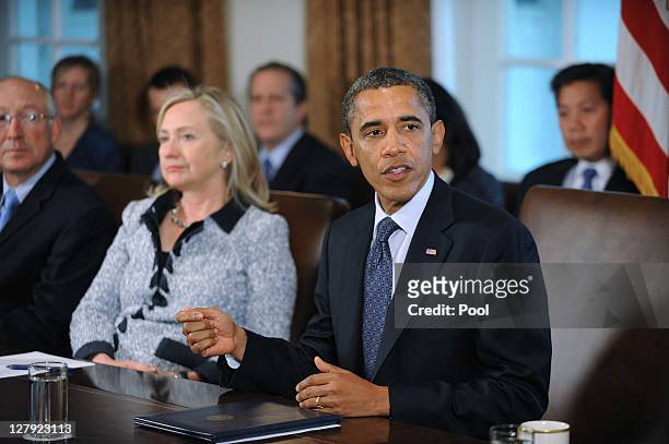President Barack Obama speaks during a Cabinet Meeting as U.S. Secretary of State Hillary Clinton listens in the Cabinet Room October 3, 2011 at the...